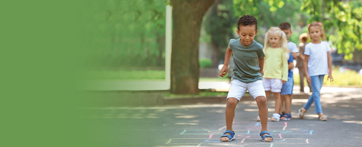 Diverse group of children playing hopscotch on the playground