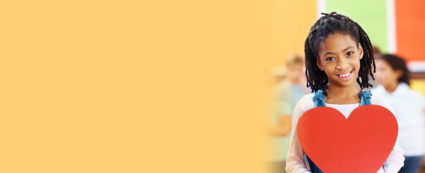 Young girl holding a paper heart.