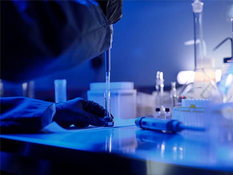 Close up of the arms of person in a lab performing a task.
