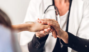 Doctor holding the hand of a patient