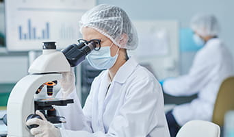 Medical researcher using a microscope