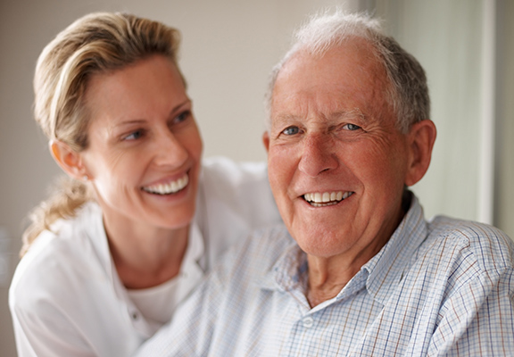 Older man smiling with nurse