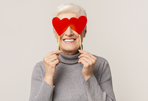 Woman holding hearts over eyes